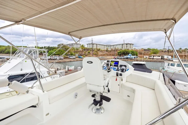 Slide: The Image of 2023 ArrowCat 420 Flybridge yacht interior with helm, docked at marina. - 34