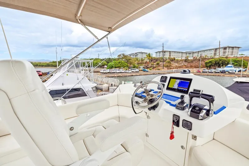 Slide: The Image of 2023 ArrowCat 420 Flybridge yacht helm with modern controls and scenic marina view. - 36