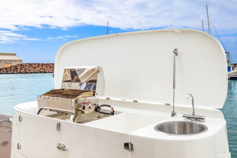 Slide: The Image of 2023 ArrowCat 420 Flybridge yacht with outdoor kitchen and sink, docked by the sea. - 42