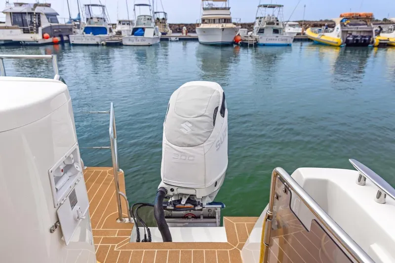 Slide: The Image of 2023 ArrowCat 420 Flybridge with Suzuki outboard motor in a marina setting. - 58