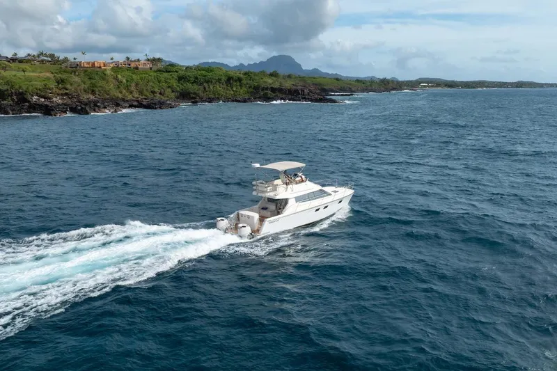 Slide: The Image of 2023 ArrowCat 420 Flybridge cruising along scenic coastline under cloudy sky. - 6