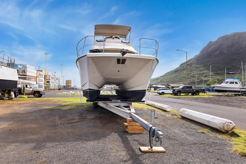 Slide: The Image of 2023 ArrowCat 420 Flybridge boat on trailer in a scenic marina setting. - 65