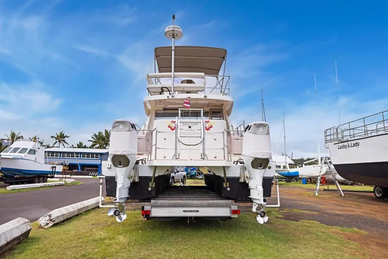 Slide: The Image of 2023 ArrowCat 420 Flybridge yacht on trailer in marina, clear sky background. - 66