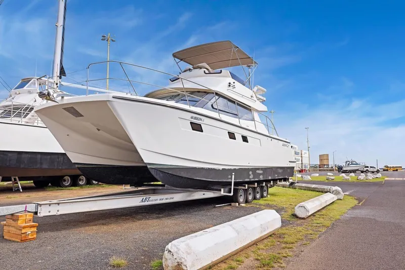 Slide: The Image of 2023 ArrowCat 420 Flybridge yacht on trailer under clear blue sky. - 67