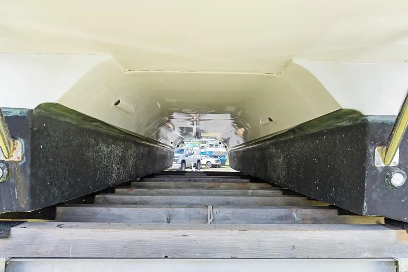 Slide: The Image of Underside view of 2023 ArrowCat 420 Flybridge catamaran on a wooden platform. - 76