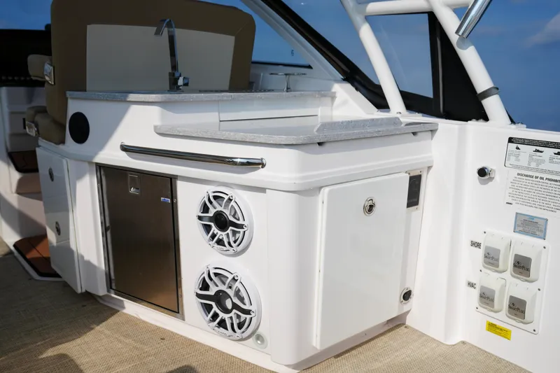 Slide: The Image of 2023 Everglades 340 Dual Console boat cruising on open water, twin engines visible. - 10