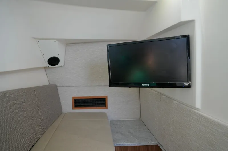 Slide: The Image of 2023 Everglades 340 Dual Console cabin interior with seating and TV. - 18