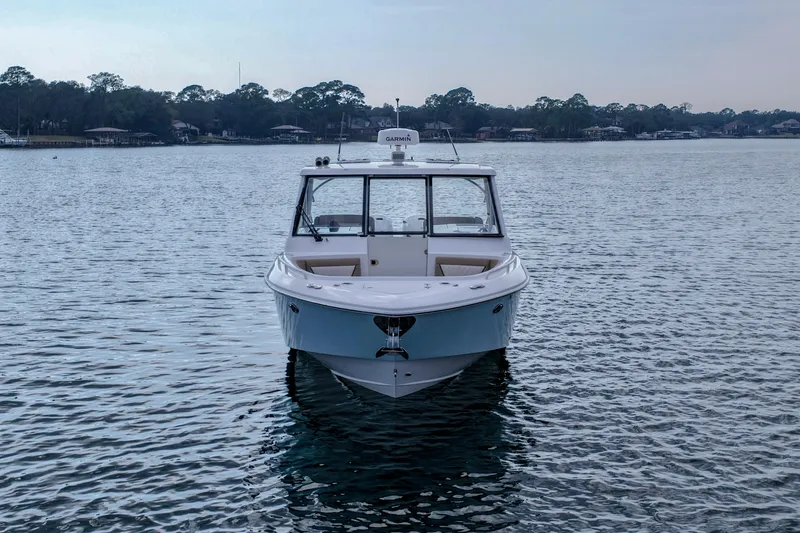 Slide: The Image of 2023 Everglades 340 Dual Console boat on calm water, surrounded by trees. - 38