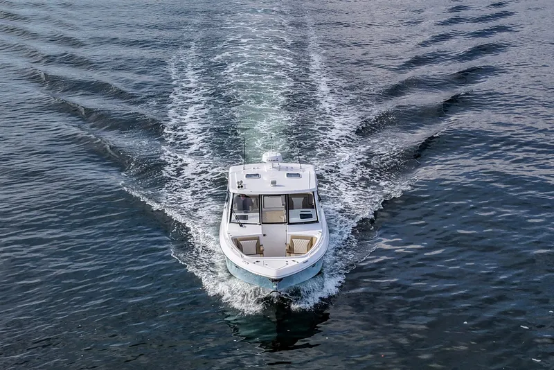 Slide: The Image of 2023 Everglades 340 Dual Console boat cruising on open water, aerial view. - 45