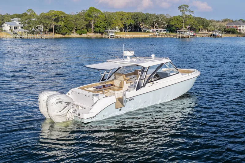 Slide: The Image of 2023 Everglades 340 Dual Console boat on serene water, showcasing sleek design and powerful engines. - 50