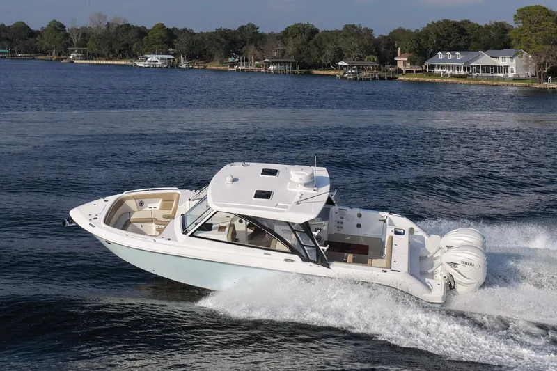 Slide: The Image of 2023 Everglades 340 Dual Console boat cruising on a scenic lake. - 64