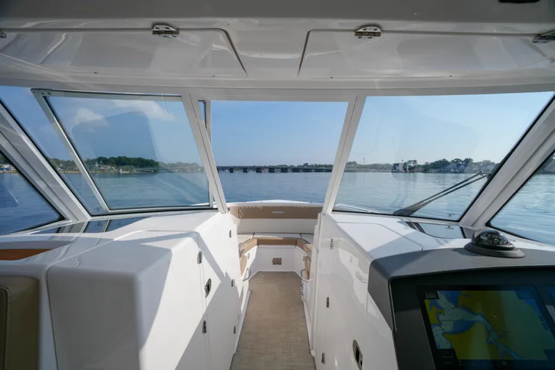 Slide: The Image of Interior of 2023 Everglades 340 Dual Console boat with beige seating and lake view. - 7