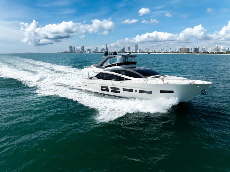 Slide: The Image of Astondoa 80 GLX yacht cruising on open water, city skyline in background, 2016 model. - 12