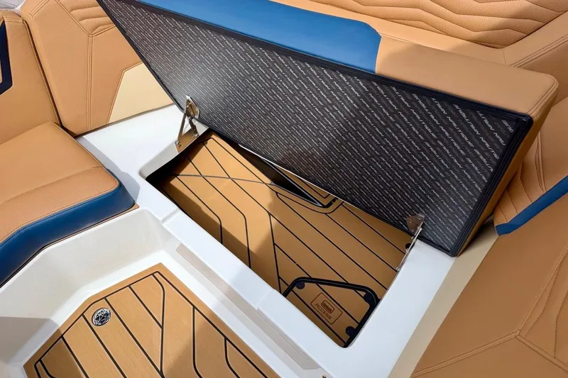 Slide: The Image of 2026 Nautique Super Air Nautique G23 boat interior storage compartment with tan and blue seating. - 21