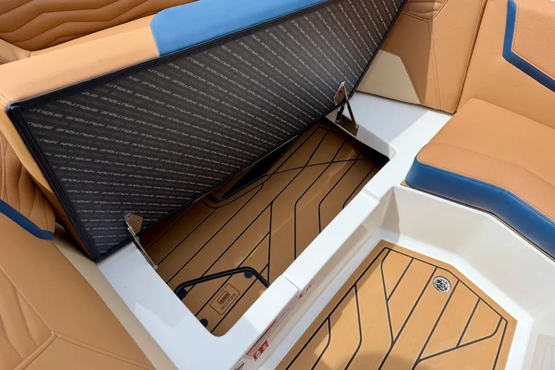 Slide: The Image of 2026 Nautique Super Air Nautique G23 interior storage compartment with tan and blue seating. - 22