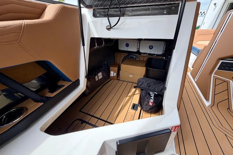 Slide: The Image of Interior storage area of 2026 Nautique Super Air Nautique G23 boat with tan seating. - 29