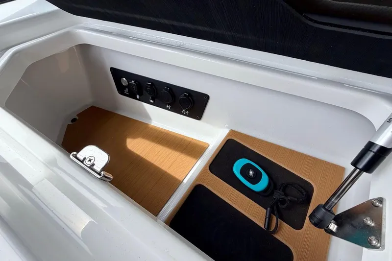 Slide: The Image of 2026 Nautique Super Air Nautique G23 storage compartment with control panel and accessories. - 31
