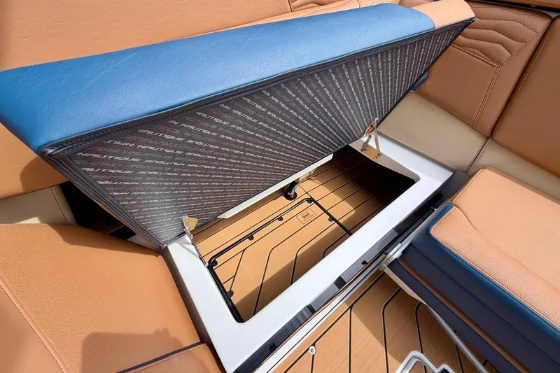 Slide: The Image of 2026 Nautique Super Air Nautique G23 storage compartment with blue and tan seating. - 33