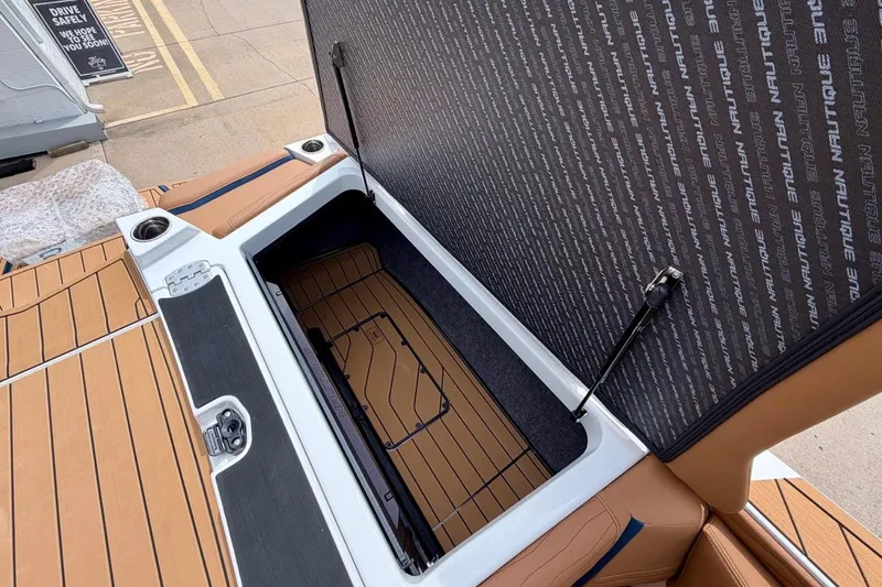 Slide: The Image of 2026 Nautique Super Air Nautique G23 boat storage compartment with open hatch and teak flooring. - 34