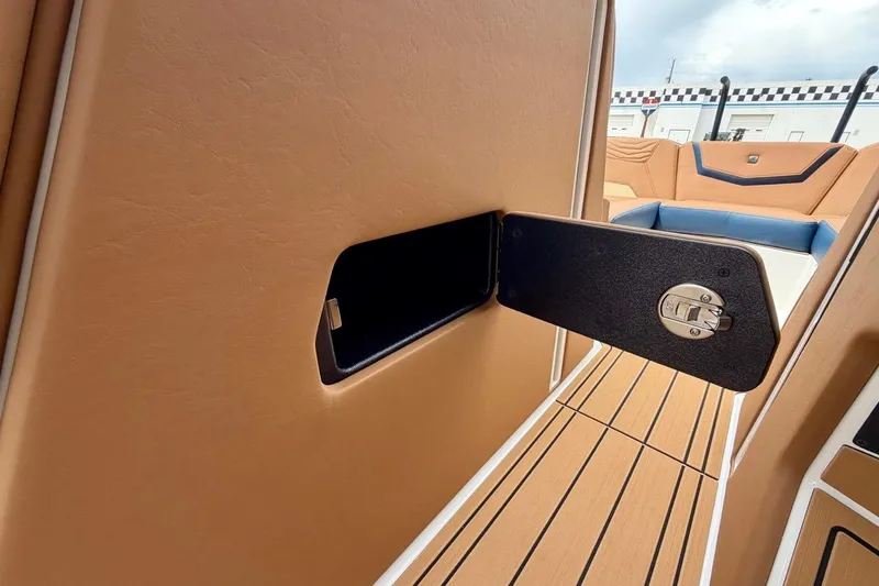 Slide: The Image of 2026 Nautique Super Air Nautique G23 interior with tan upholstery and storage compartment. - 42