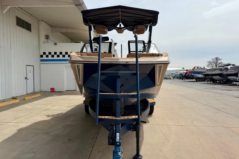 Slide: The Image of 2026 Nautique Super Air Nautique G23 boat on trailer, parked outside a building. - 6