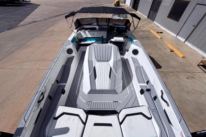 Slide: The Image of 2026 Nautique Ski Nautique boat with sleek interior design, docked at a marina. - 10