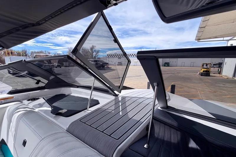 Slide: The Image of 2026 Nautique Ski Nautique boat interior with open windshield, showcasing sleek design and seating. - 22