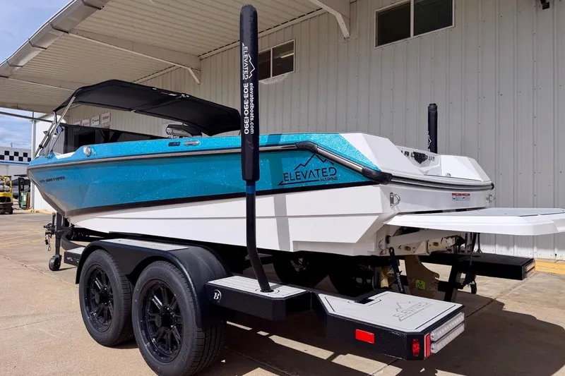 Slide: The Image of 2026 Nautique Ski Nautique boat on trailer, blue and white, parked outdoors. - 4