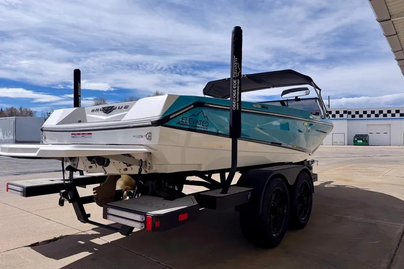 Slide: The Image of 2026 Nautique Ski Nautique boat on trailer, parked outdoors under a partly cloudy sky. - 7