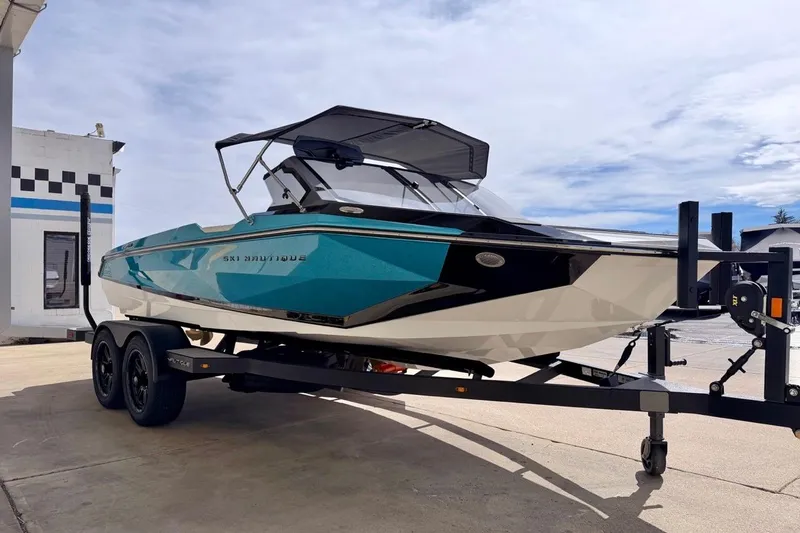 Slide: The Image of 2026 Nautique Ski Nautique boat on trailer, teal and white design, parked outdoors. - 8
