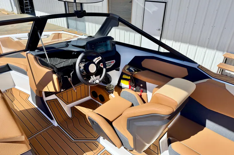 Slide: The Image of 2026 Nautique Super Air Nautique S21 interior with tan upholstery and modern dashboard design. - 11