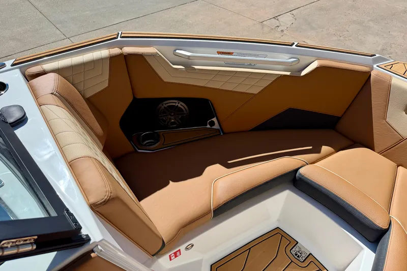 Slide: The Image of 2026 Nautique Super Air Nautique S21 interior with tan upholstery and speaker system. - 16