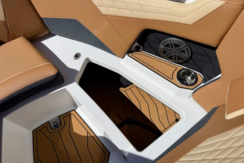 Slide: The Image of 2026 Nautique Super Air Nautique S21 interior with tan upholstery and speaker system. - 17