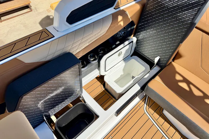Slide: The Image of 2026 Nautique Super Air Nautique S21 interior with open storage compartments and cup holders. - 19