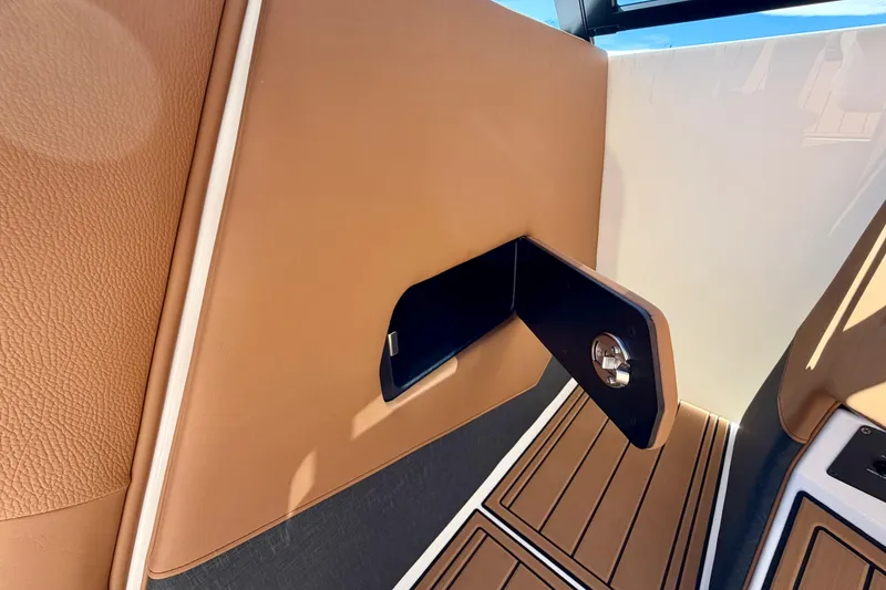 Slide: The Image of 2026 Nautique Super Air Nautique S21 interior detail with tan leather and storage compartment. - 23