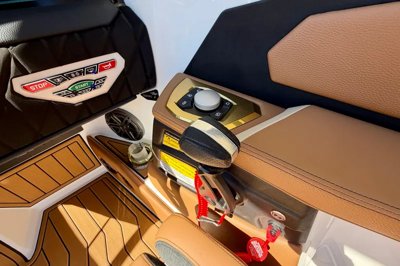 Slide: The Image of 2026 Nautique Super Air Nautique S21 interior controls with tan upholstery and modern dashboard. - 26