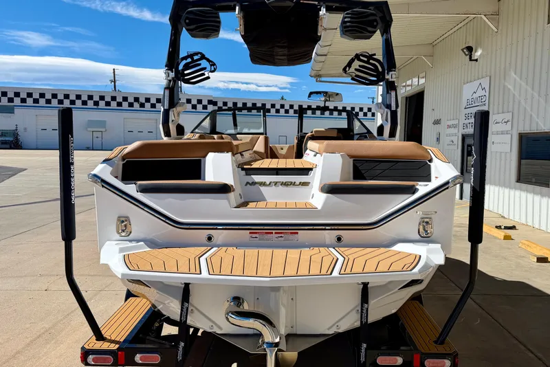 Slide: The Image of 2026 Nautique Super Air Nautique S21 boat, rear view, parked at a marina. - 4