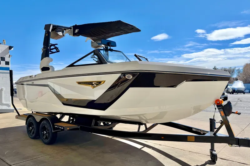 Slide: The Image of 2026 Nautique Super Air Nautique S21 boat on trailer under clear blue sky. - 8