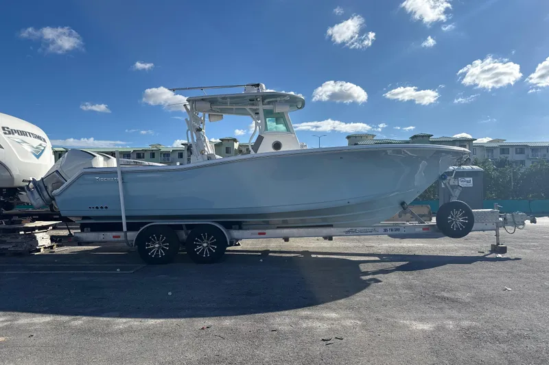 Slide: The Image of 2017 Tidewater 280 CC Adventure boat on trailer under clear blue sky. - 1
