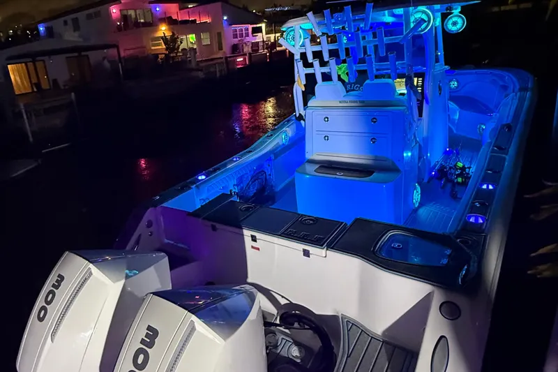 Slide: The Image of 2017 Tidewater 280 CC Adventure boat illuminated with blue LED lights at night. - 12