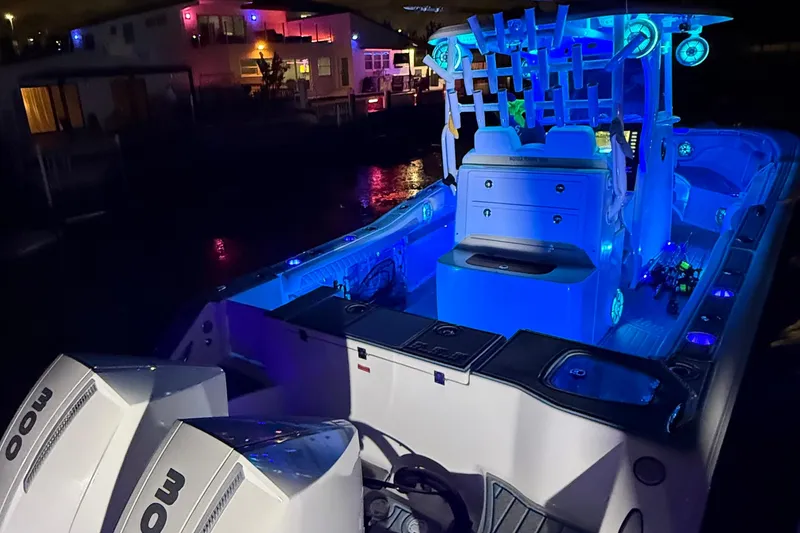 Slide: The Image of 2017 Tidewater 280 CC Adventure boat illuminated with blue LED lights at night. - 13