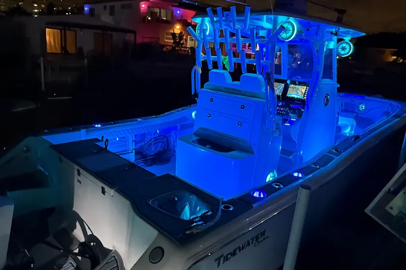 Slide: The Image of 2017 Tidewater 280 CC Adventure boat illuminated with blue LED lights at night. - 15