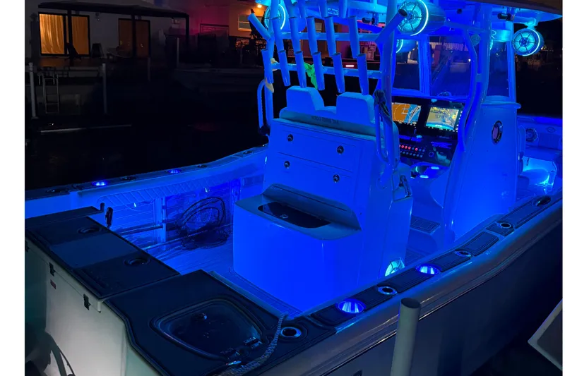 Slide: The Image of 2017 Tidewater 280 CC Adventure boat illuminated with blue LED lights at night. - 16