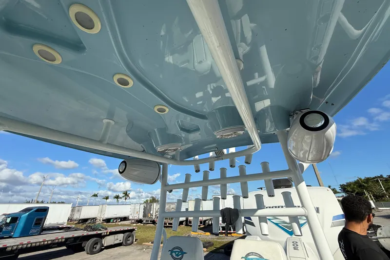Slide: The Image of 2017 Tidewater 280 CC Adventure boat interior with rod holders and speakers under blue sky. - 4