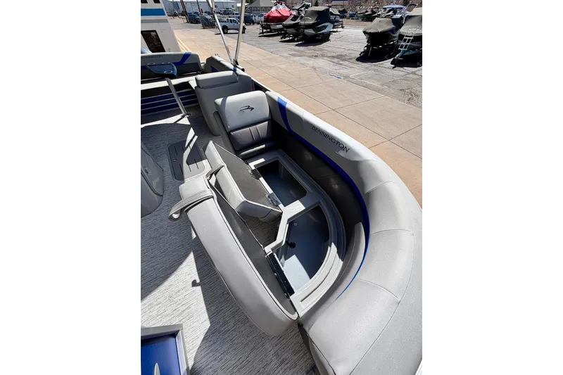 Slide: The Image of 2026 Bennington 22 SX Swingback boat interior with gray seating and storage compartments. - 16