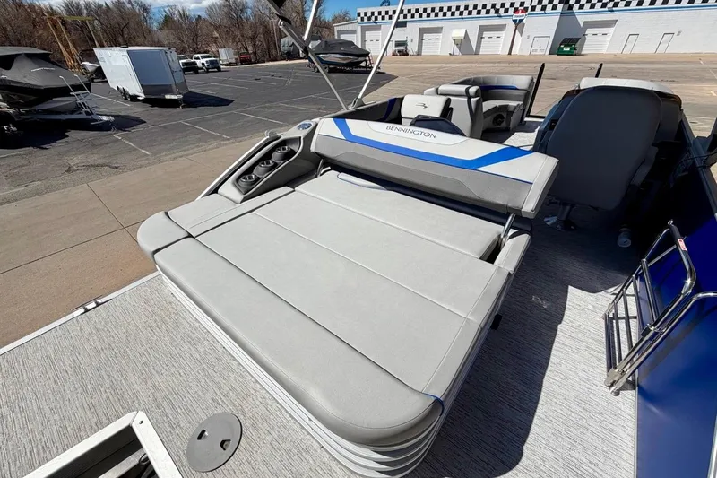 Slide: The Image of 2026 Bennington 22 SX Swingback boat with spacious seating and modern design in a parking lot. - 23