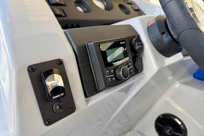 Slide: The Image of Dashboard of 2026 Bennington 22 SX Swingback with audio controls and power top switch. - 26