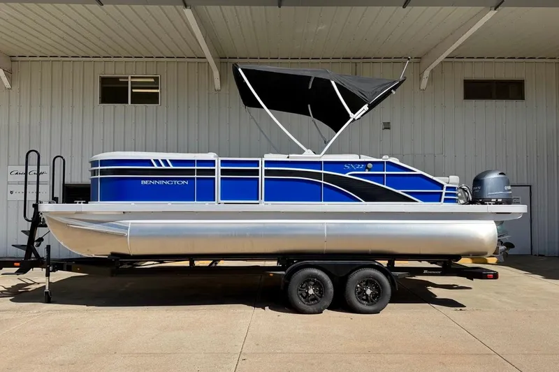 The Image of 2026 Bennington 22 SX Swingback pontoon boat on trailer, blue and silver design. - 3