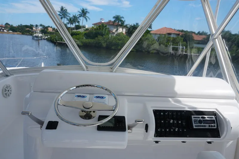 Slide: The Image of Helm of 2005 Mirage Yachts 40 Convertible with scenic waterfront view. - 24