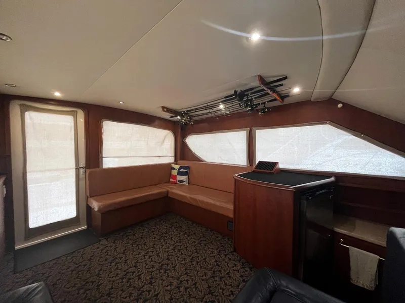 Slide: The Image of Interior of 2005 Mirage Yachts 40 Convertible with seating, fishing rods, and mini fridge. - 34